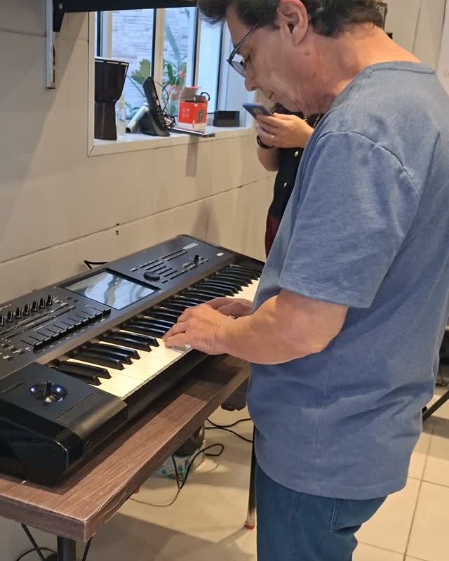 Aluno tocando teclado durante a aula