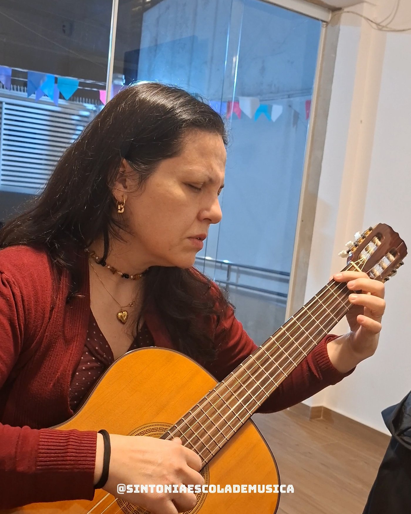 Professora tocando violão clássico em sala de aula